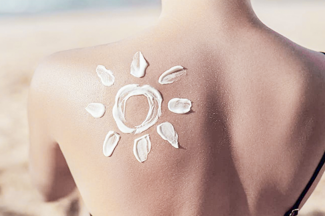 Frau trägt Sonnencreme auf
